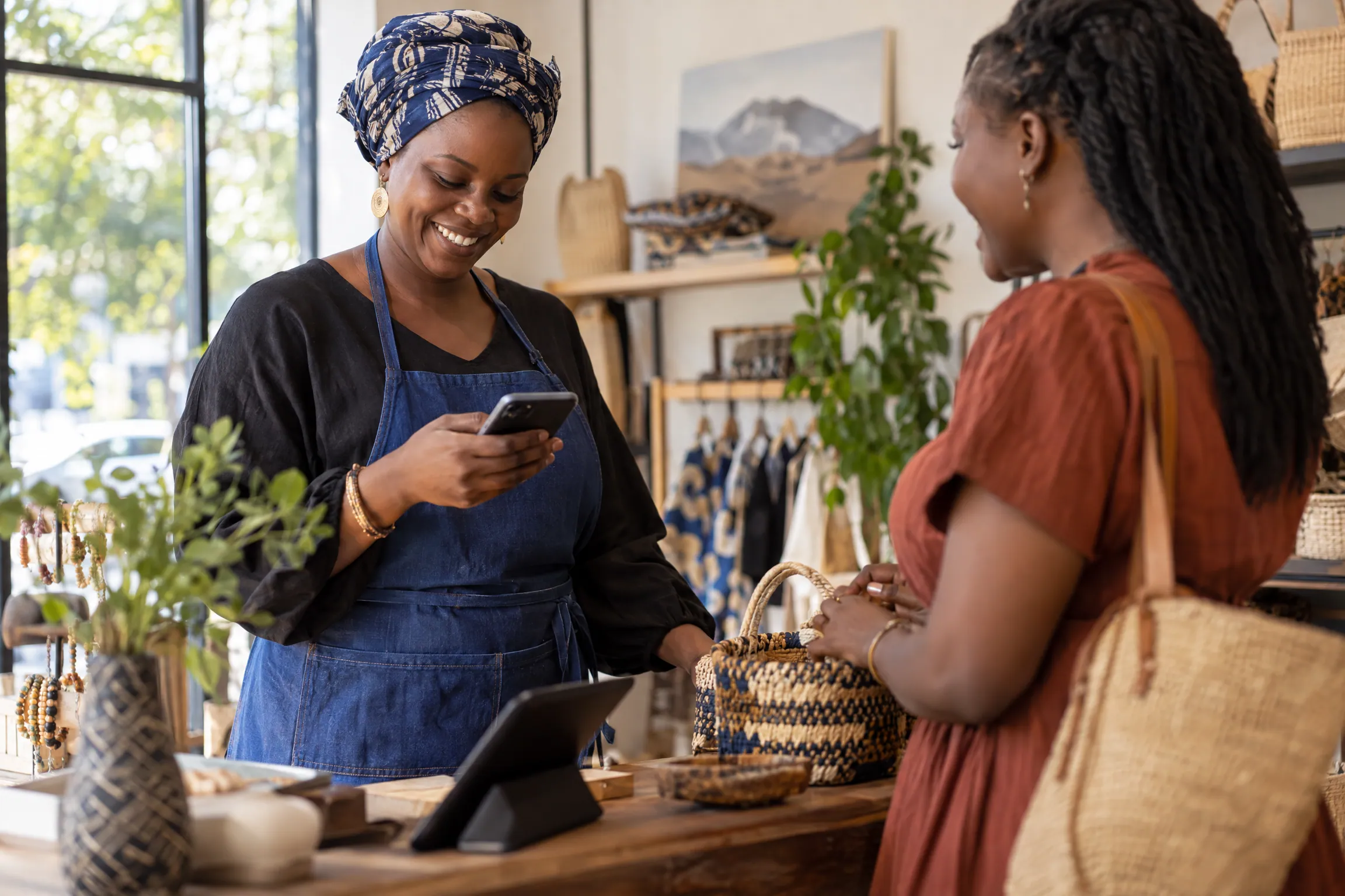 A Tanzanian small business owner checking a phone during the workday